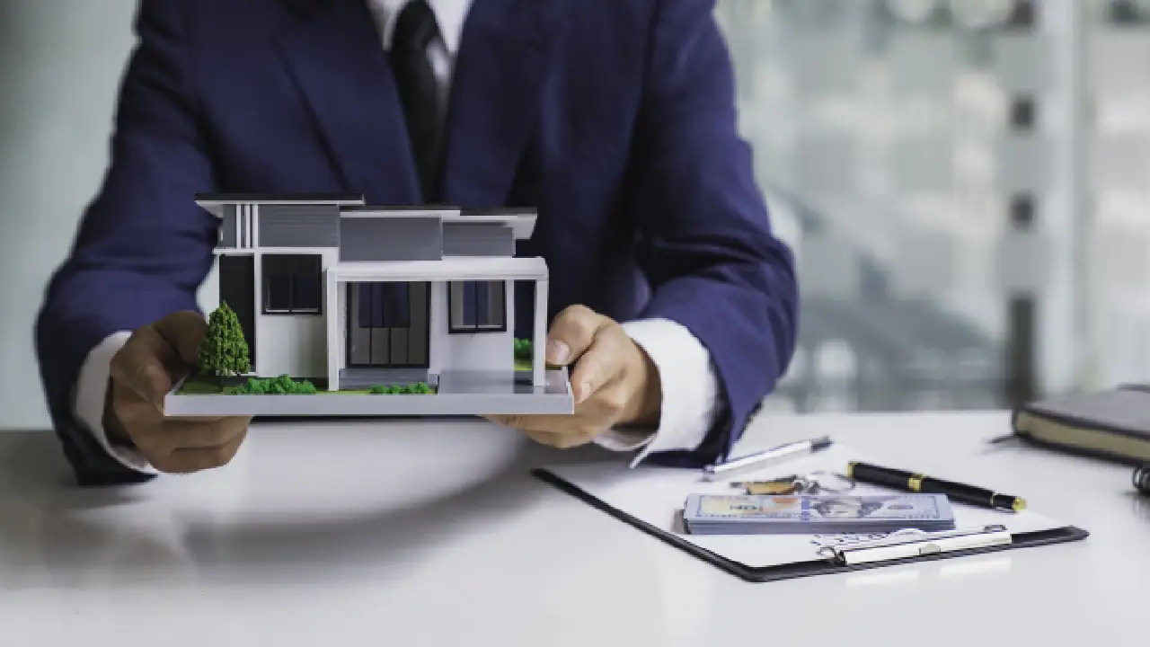 Man holding a house model, representing real estate investment and hard money lending in Florida