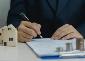 How DSCR Loans Help Real Estate Investors Scale Their Portfolios 3 Investor signing a loan agreement representing completion of the DSCR loan application process