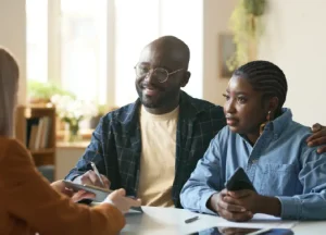 Fix and Flip Loans vs. Hard Money Loans: Which One Fits Your Strategy? 2 A couple discussing Fix and Flip Loans and Hard Money Loans with a financial advisor, reviewing documents together at a table.