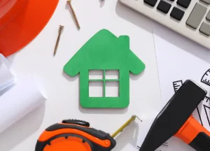 The Guide to Fix and Flip Loans for Beginners in Real Estate 2 "Building a house with tools on the table, representing home renovation, rehab financing, and fix and flip loan projects.