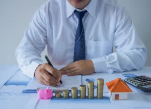 The Advantages of DSCR Loans for Real Estate Investors 3 Investor making notes on paper and whiteboard with property and cash flow calculations, illustrating DSCR loans and long-term real estate investment strategy