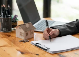 Fix and Flip Loans in 2026: Market Trends Every Investor Should Watch 3 Real estate investor planning with a laptop and documents while reviewing market data and investment strategies.